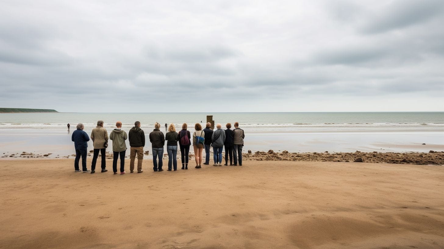 Visitors Standing On Omaha Beach, Gazing At The Horizon. Visitors standing on Omaha Beach, gazing at the horizon.
